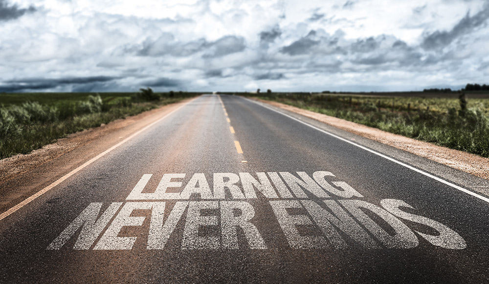 Learning Never Ends Painted on a Rural Highway