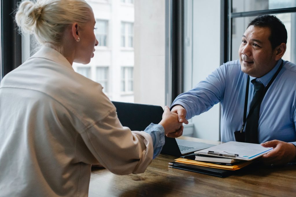 male employer confidently shaking had of female candidate