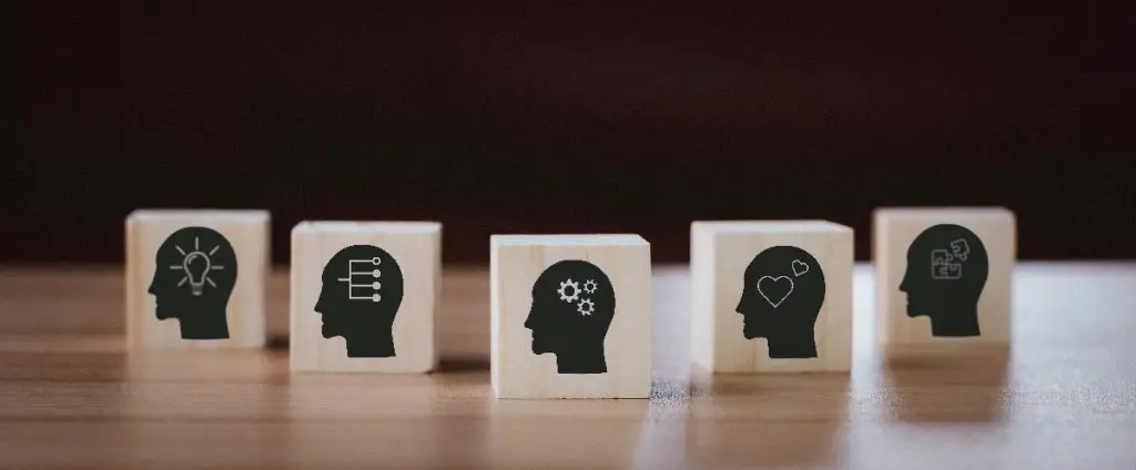 A collection of wooden blocks featuring human heads, symbolizing the importance of soft skills in teamwork and collaboration